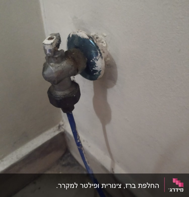 ברז מים ישן עם צינור כחול מחובר